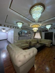 拉各斯Ikorodu Guest House的带沙发、桌子和吊灯的客厅