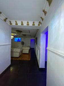 拉各斯Ikorodu Guest House的客厅配有白色家具和紫色灯