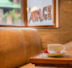 斯利那加幻影酒店的沙发旁桌子上的咖啡杯