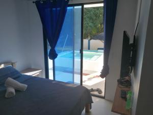 班塔延岛Villa Jana, Bantayan, Santa Fe的一间卧室配有一张床,享有游泳池的景色