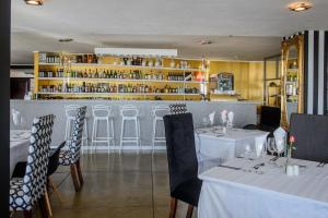 内尔斯普雷特富兰克林旅馆的一间设有白色桌椅的餐厅和一间酒吧