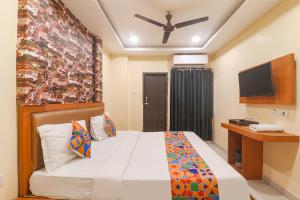 KakarmathaFabHotel Swarn Banquet的一间酒店客房,配有一张床和一台电视
