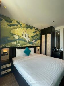 绥和市Luna Apartment - Apec Mandala Phú Yên的一间卧室配有一张白色大床和绘画