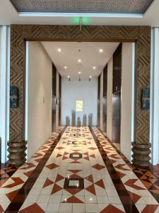 绥和市Luna Apartment - Apec Mandala Phú Yên的大楼内空空的走廊,有格子地板