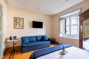 罗马玛蒂娜别墅的一间卧室配有蓝色的沙发和一台电视机