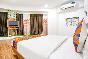 苏拉特FabHotel 7 Star的卧室配有一张白色大床和电视。