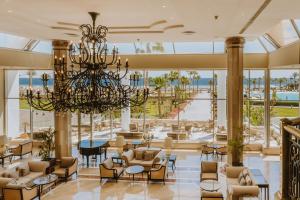 沙姆沙伊赫沙姆沙伊赫巴伦度假酒店的大型大堂设有吊灯和桌椅
