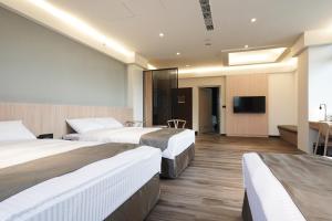 白河关子岭富野温泉会馆的一间酒店客房,设有三张床和一台平面电视