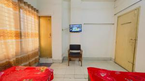 达卡Hotel Al Makka的一间带椅子和墙上电视的房间