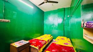 达卡Hotel Al Makka的一间设有两张床和绿色墙壁的客房