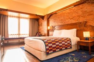 加德满都雅克和雪人酒店的一间卧室设有一张大床和砖墙