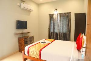 钦奈FabHotel Home Tree Service Apartment Kolathur的一间卧室设有一张床、一台电视和一个窗口。