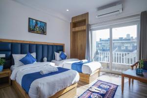 瑞诗凯诗Tripli Hotels Ayushman Retreat的酒店客房设有两张床和大窗户。