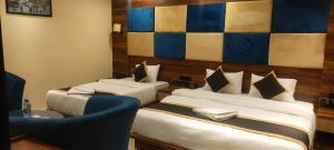 Koch BihārPoddar Residency的酒店客房,设有两张床和一张蓝色椅子