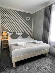 比什凯克Kausar Hotel的一间卧室配有一张床,上面有两条毛巾