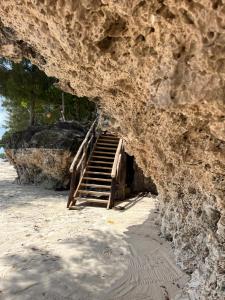 南威Sazani Beach Lodge and Tidal Lounge的通往岩壁洞的楼梯