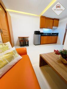 独鲁万GTC Apartelle的客厅配有橙色沙发和桌子