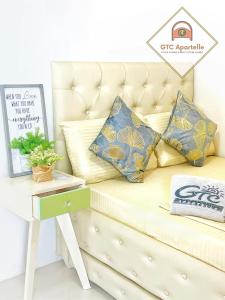独鲁万GTC Apartelle的配有枕头的沙发以及带标志的桌子