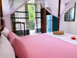 米瑞莎时代住宿加早餐旅馆的窗户客房内的粉红色床铺