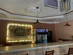 卢萨卡JUBILEE EXECUTIVE LODGE的餐厅内的酒吧配有柜台和冰箱