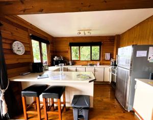 穆里Muri Vista Villas的厨房配有带凳子的柜台和冰箱。