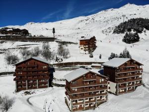 里蒙纽耶Résidence Courmayeur - 2 Pièces pour 4 Personnes 934的山旁的雪地里一群建筑物