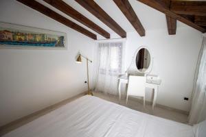基奥贾Ca' Arte e Vacanze MyTravelChioggia的白色卧室配有床和镜子