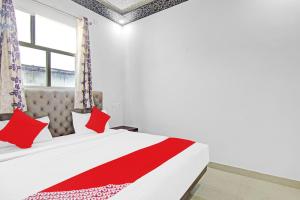 加济阿巴德OYO Flagship 87416 Hotel Moonstar的一间卧室配有一张带红色枕头的床和一扇窗户