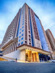 麦加TIME Ruba Hotel & Suites的街道上高大的建筑,有蓝色的窗户