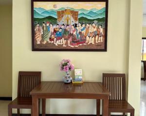南府Ponburi Hotel的木桌上方墙上的画
