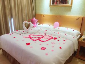 The Grace Hotel Shanghai Yexie的一张有两只天鹅和一只心的睡床
