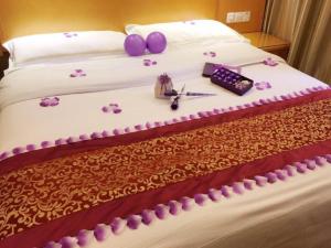 The Grace Hotel Shanghai Yexie的一张布满紫色花的睡床