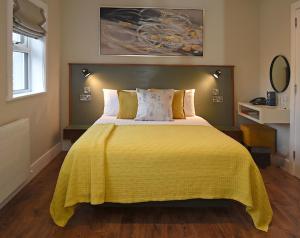 梅奥Moy Hotel的一间卧室配有一张带黄色毯子的大床