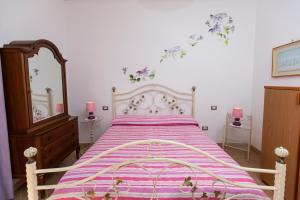 阿杰罗拉圣安娜住宿加早餐旅馆的一间卧室配有一张大床和紫色毯子