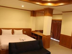 Ban Tha PhaeLoei Residence的一间卧室配有一张床和一张书桌