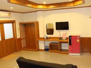 Ban Tha PhaeLoei Residence的客厅配有书桌和红色冰箱。