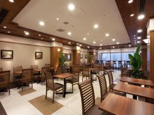 丰冈市Toyooka Green Hotel Morris的一间空餐厅,配有木桌和椅子