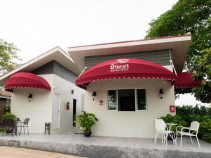 Ban Nong ChikBaan Kula Mahasarakam的餐厅设有红色遮阳篷和桌椅