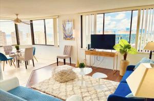 檀香山Hawaiian Monarch Penthouse 401 by Hawaii Ocean Club的客厅配有蓝色的沙发和电视