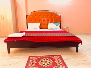 新德里Bharat Vandana Stay near Yashobhoomi的一张带橙色床头板和红色毯子的床