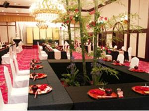 都城市Miyakonojo Royal Hotel的宴会厅配有黑桌和白色椅子