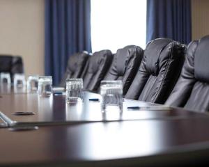 弗登Comfort Inn & Suites的一间会议室,配有桌子和黑椅子