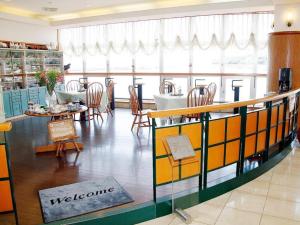 龟之浦Tara Kanko Hotel的餐厅设有桌椅和迎宾标志