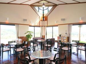 一关Tategamori Kogen Hotel的餐厅设有桌椅和窗户。