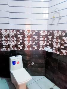 新德里Bharat Vandana Stay near Yashobhoomi的浴室设有卫生间,墙上挂着粉红色的鲜花