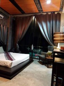 Ban Noi Pho KhamTheloft boutique nakhonpanom的一间卧室设有一张床和一间客厅。
