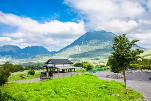 由布市Yufuin Tsukahara Villa ERINA的山丘上以山为背景的房子