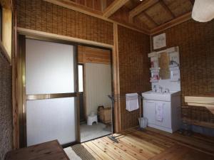 由布市Yufuin Tsukahara Villa ERINA的客房设有带门和水槽的厨房