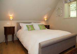 金斯布里奇格里布农场住宿加早餐旅馆的卧室配有一张带两个绿色枕头的大型白色床
