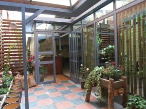 昆明Pankun Business Hotel的种植了盆栽植物的温室和木凳